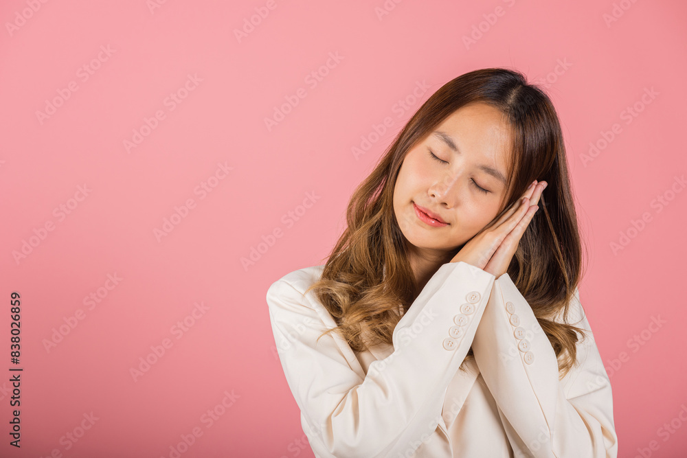 Portrait Asian beautiful young woman pretended emotions sleeping tired eyes closed dreaming with hands together near face, studio shot on pink background, with copy space, insomnia concept Portrait Asian beautiful young woman pretended emotions sleeping tired eyes closed dreaming with hands together near face, studio shot on pink background, with copy space, insomnia concept