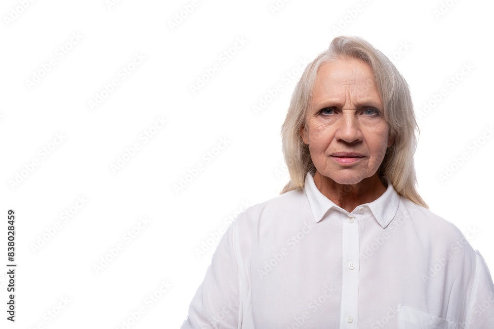 Pensioner woman with gray hair feels suspicious looking at camera Pensioner woman with gray hair feels suspicious looking at camera