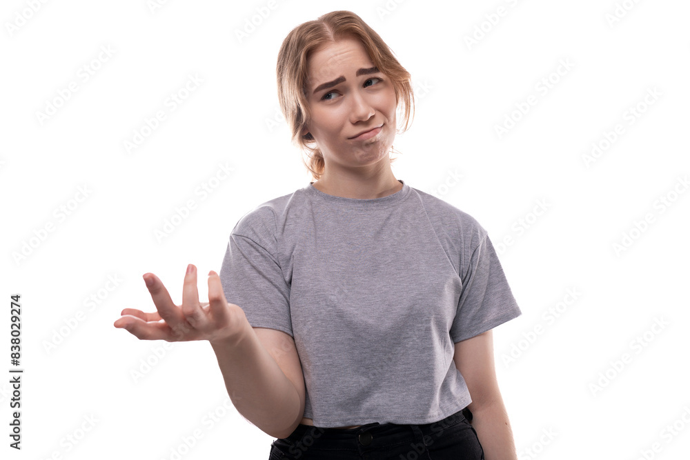 Confused fair-haired teenage girl in a gray T-shirt doubts Confused fair-haired teenage girl in a gray T-shirt doubts