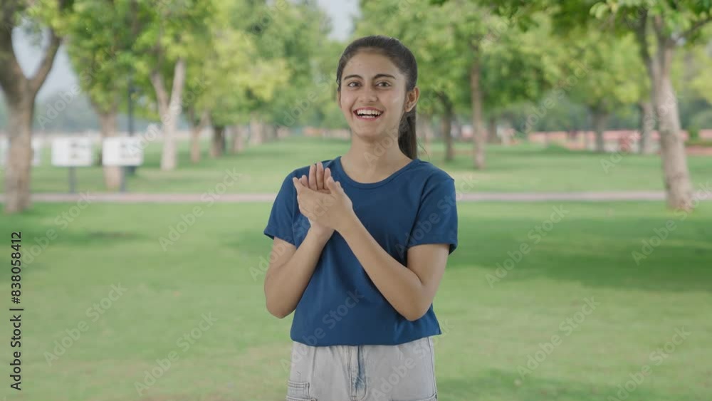 Happy Indian teenage girl clapping and appreciating in park Happy Indian teenage girl clapping and appreciating in park