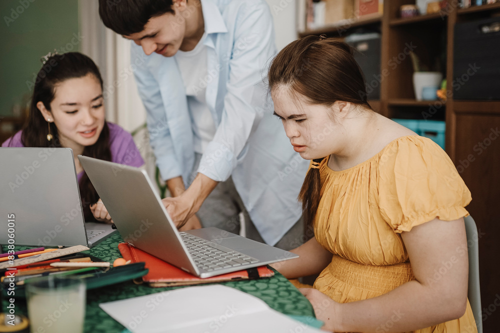 Woman with down syndrome learning through laptop by siblings at home Woman with down syndrome learning through laptop by siblings at home