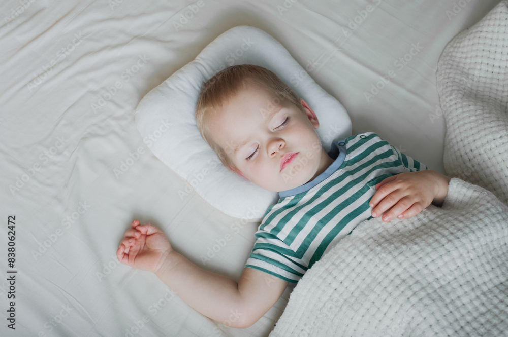 Naklejka premium Toddler boy sleeping close-up on bed. Health care concept