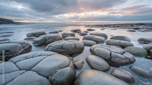 Serene Seascape at Dusk with Smooth Stones and Cloudy Skies