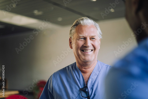 Cheerful senior male physician with colleague in hospital photo