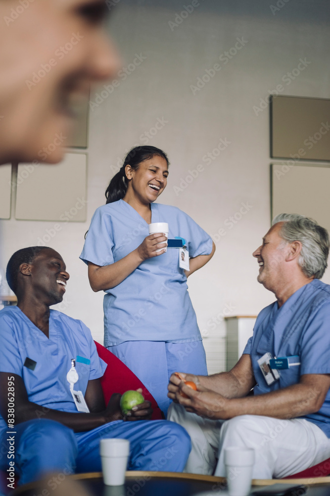 Cheerful multiracial healthcare workers talking in cafeteria of hospital Cheerful multiracial healthcare workers talking in cafeteria of hospital