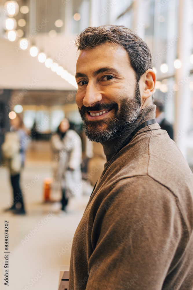 © Maskot - Side view portrait of smiling male entrepreneur at convention center