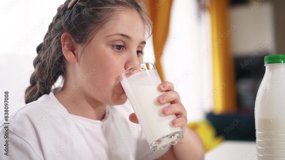 child dirty drinks milk. healthy a eating children concept. child girl drinks milk in the kitchen stained lips funny rejoices smiling. daughter lifestyle whale drinks milk child dirty drinks milk. healthy a eating children concept. child girl drinks milk in the kitchen stained lips funny rejoices smiling. daughter lifestyle whale drinks milk