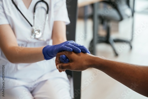 Blue gloves. Two doctors are holding hands indoors