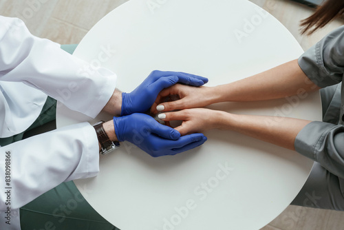 Focused view. Two doctors are holding hands indoors