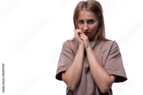 Foto Fearful adult woman with blond hair on white background with copy space
