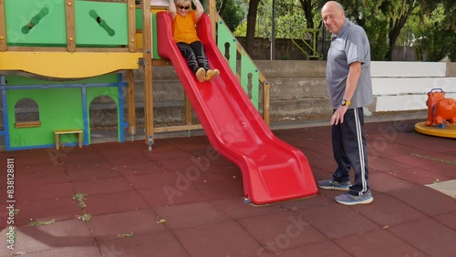 nice elderly couple playing at the children's playground, with slide, swing and rides. youth in the elderly.