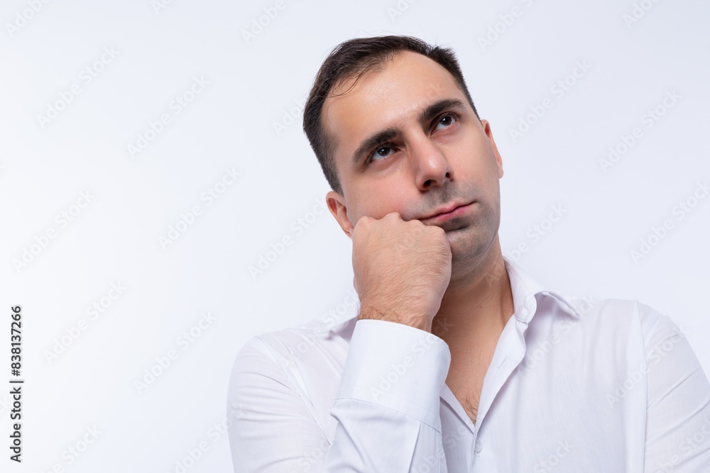 Portrait of an excited European brunette man in a white shirt holding his head Portrait of an excited European brunette man in a white shirt holding his head