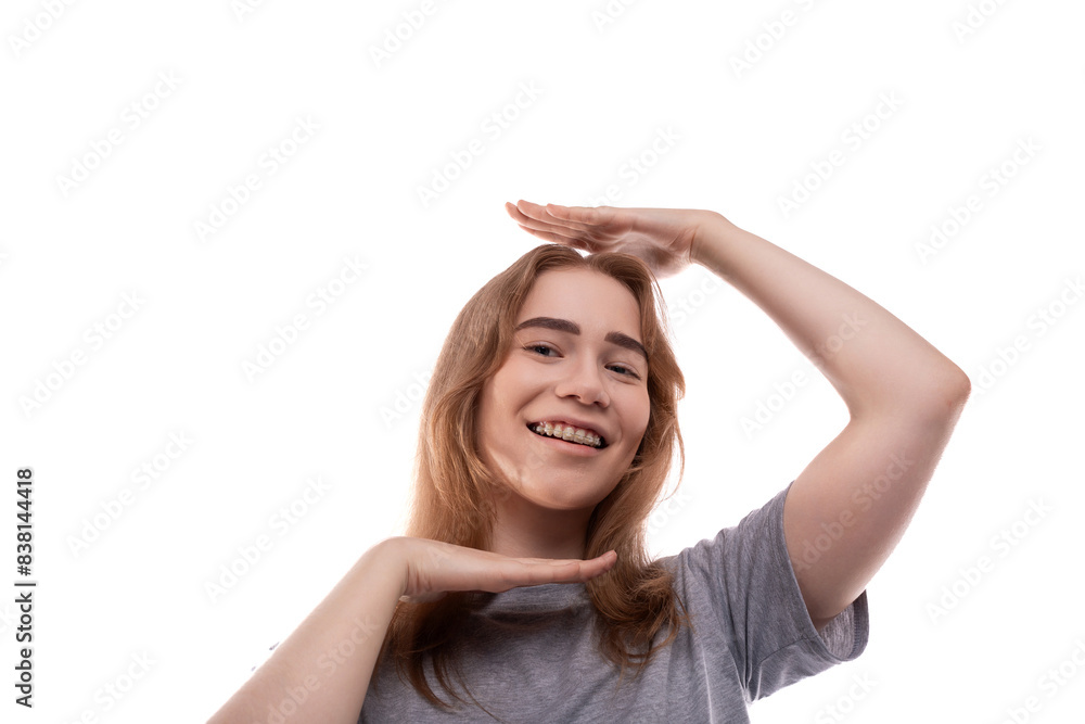 Smiling teenage girl with blond hair in a T-shirt on a white background