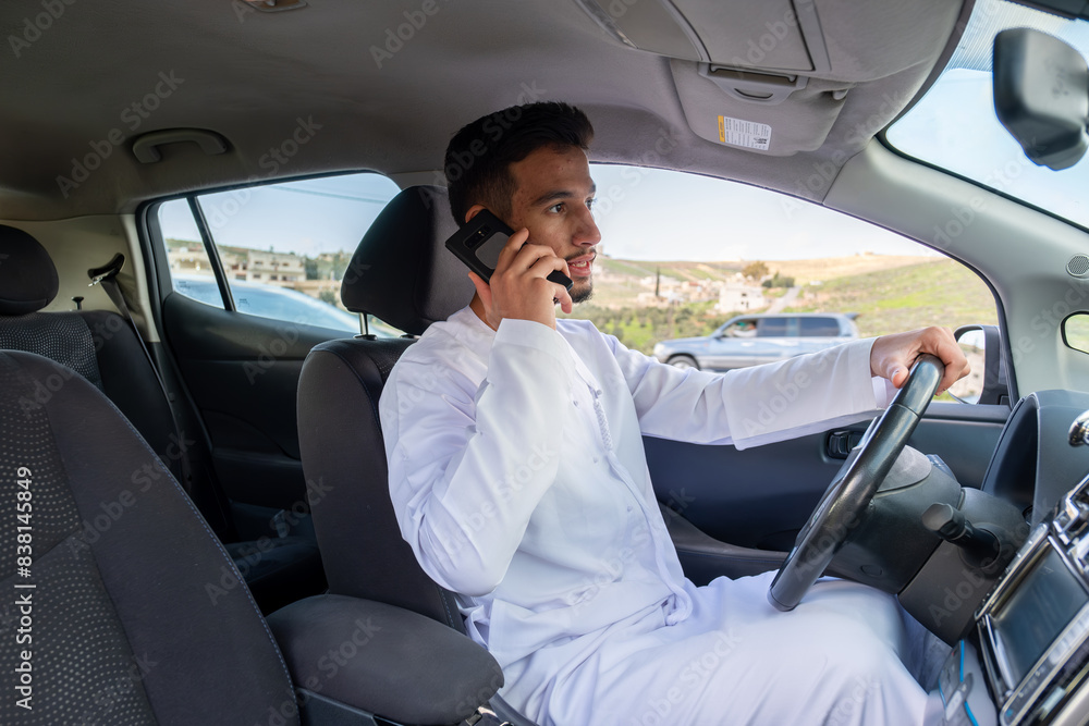 Young arab male using mobile phone while driving Young arab male using mobile phone while driving