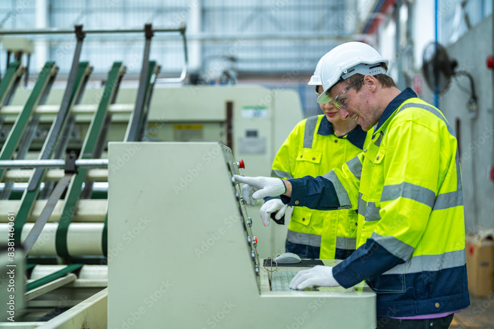 Male and female engineers in neat work clothes prepare and control the production system of large modern machines in a factory producing industrial technology products. Male and female engineers in neat work clothes prepare and control the production system of large modern machines in a factory producing industrial technology products.