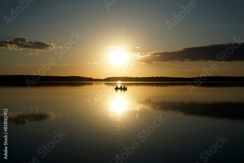 Scenic sunset over lake with boat silhouette - Masuria  Poland
