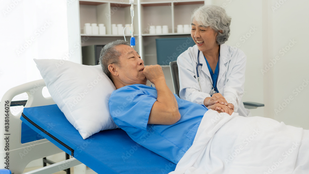 Obraz premium Senior Asian male patient visits the doctor for his annual checkup. Caregivers in caring for the elderly provide assistance on the bed Hospitals and Medicine and Health Care and Life Insurance