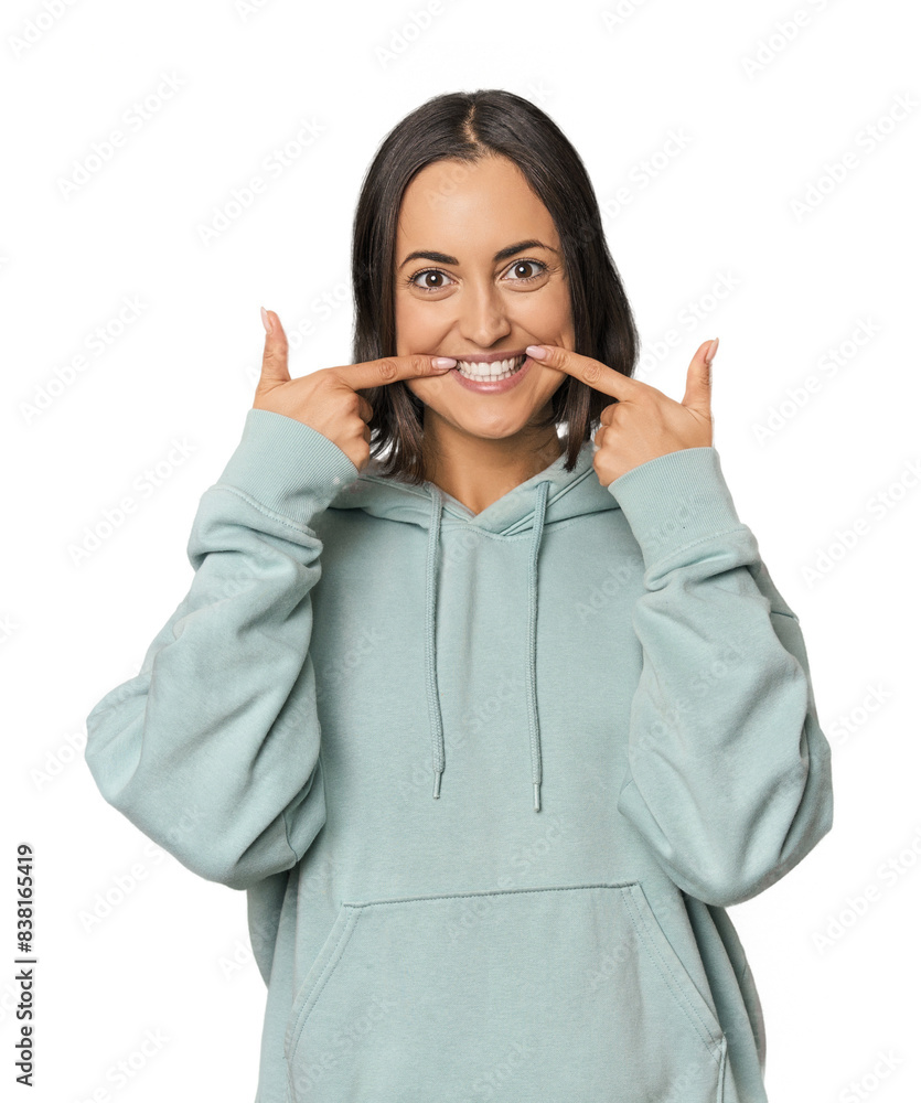 Young Caucasian woman with short hair smiles, pointing fingers at mouth. Young Caucasian woman with short hair smiles, pointing fingers at mouth.