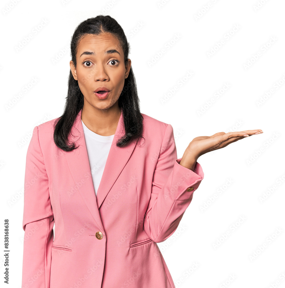 Young Filipina in pink suit impressed holding copy space on palm. Young Filipina in pink suit impressed holding copy space on palm.