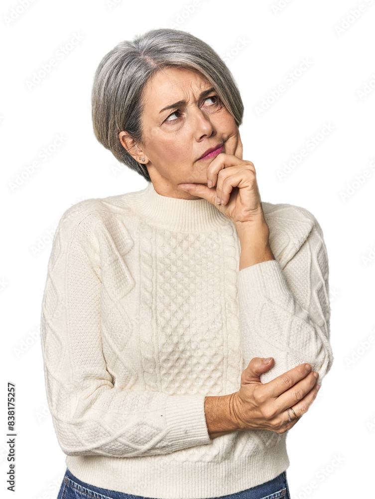 Caucasian mid-age female on studio background thinking and looking up, being reflective, contemplating, having a fantasy. Caucasian mid-age female on studio background thinking and looking up, being reflective, contemplating, having a fantasy.