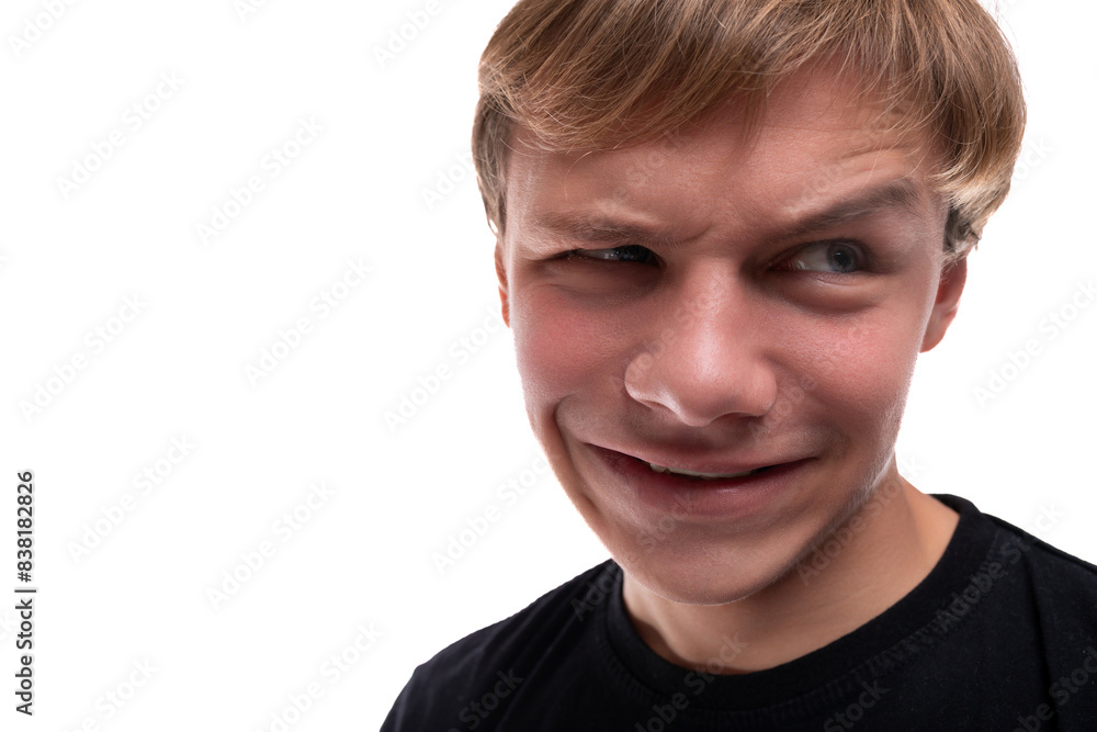 Funny teenage guy with blond hair makes a grimace