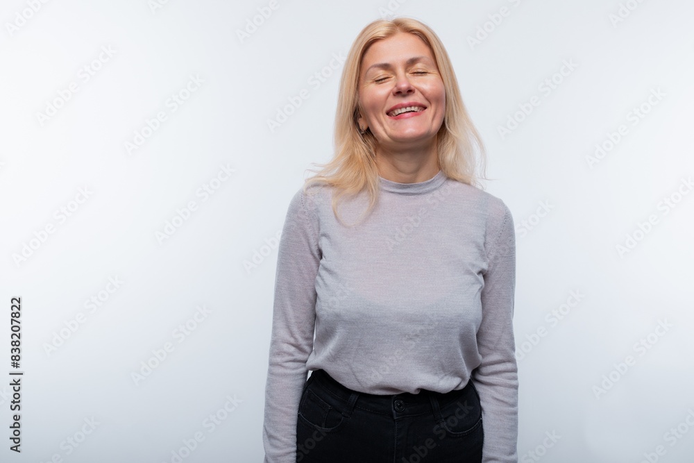 A middle-aged woman with blond hair and light makeup smiles kindly A middle-aged woman with blond hair and light makeup smiles kindly
