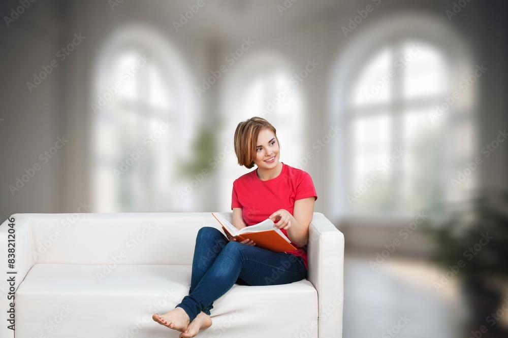 Obraz premium young happy woman reading a book at home