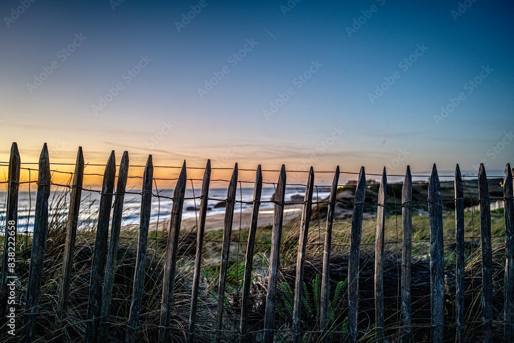 Obraz premium Fence in the dunes with sunset on the beach of Capbreton in France