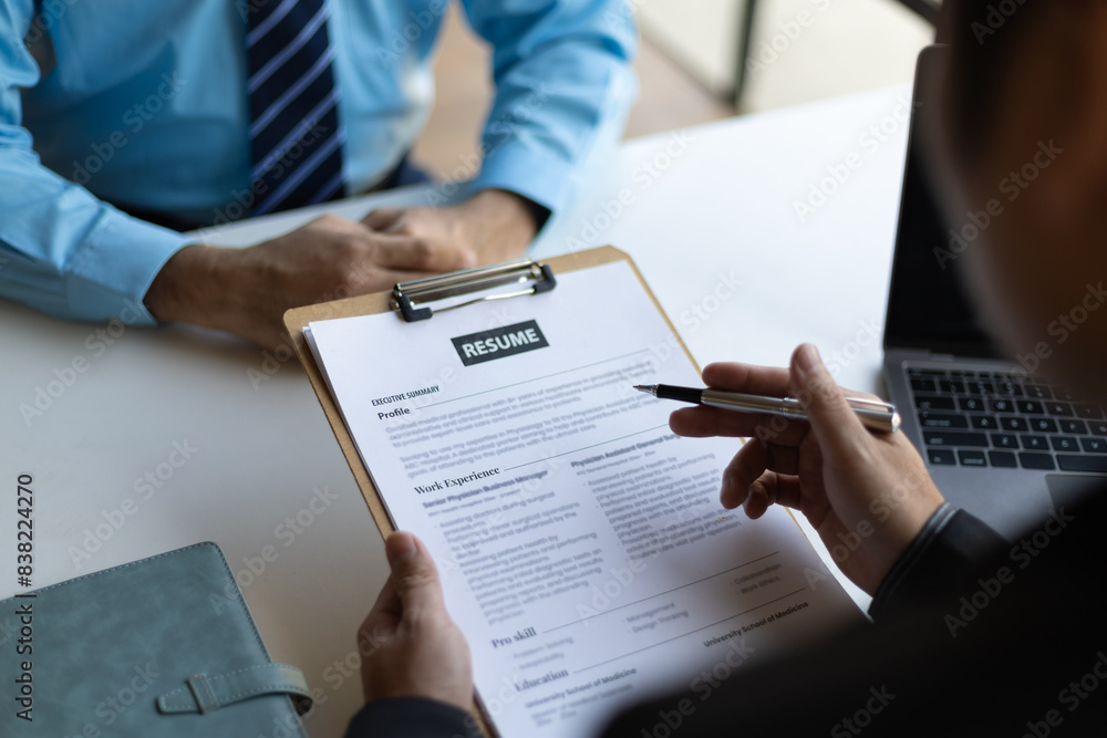 Job interviews, Employer in suit reading resume of job interview candidate profile collection. Man explaining profile to a manager sitting for a job interview. Job Search and Human Resources Job interviews, Employer in suit reading resume of job interview candidate profile collection. Man explaining profile to a manager sitting for a job interview. Job Search and Human Resources