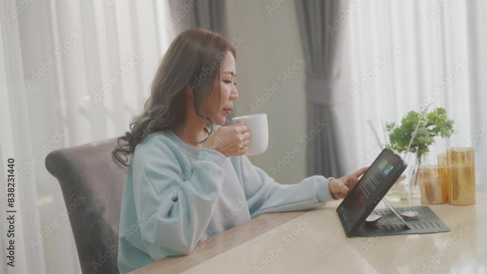 Women are playing with their mobile phones on the sofa and on the dining table and drinking coffee at the same time. Women are playing with their mobile phones on the sofa and on the dining table and drinking coffee at the same time.