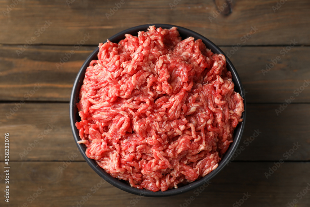 Raw ground meat in bowl on wooden table, top view Raw ground meat in bowl on wooden table, top view