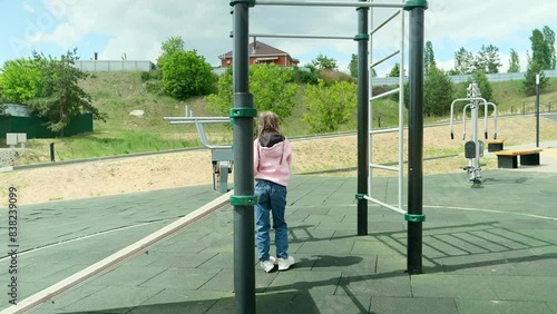Wallpaper Mural Hanging child on horizontal bar at sports ground Torontodigital.ca