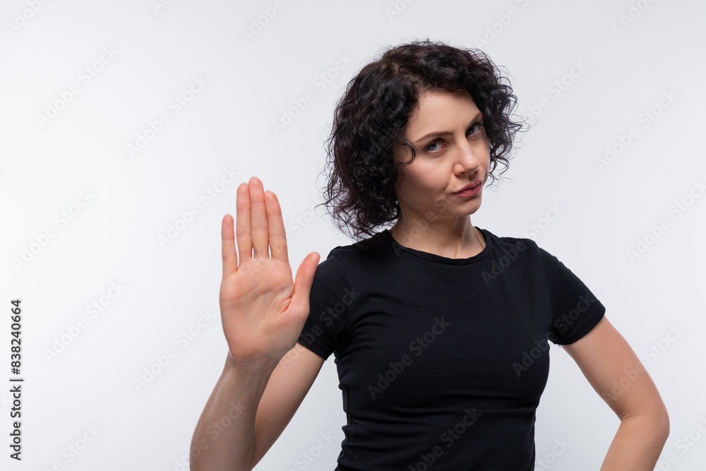 Adult curly European woman in a black T-shirt reports the news Adult curly European woman in a black T-shirt reports the news