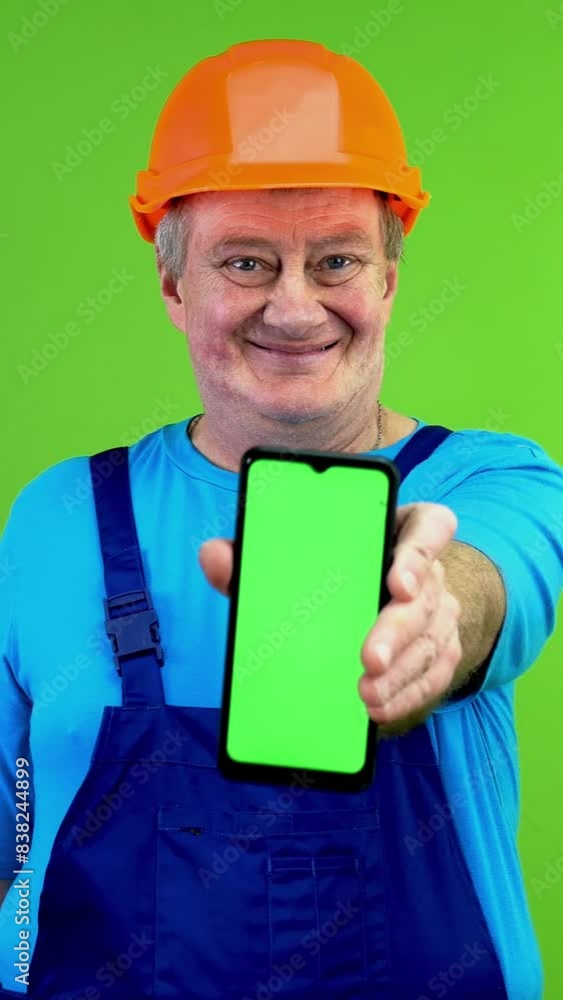 Worker showing blank green display smartphone. Worker showing blank green display smartphone.