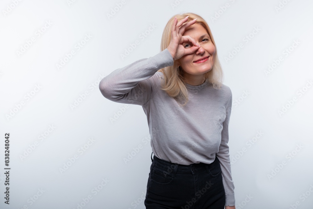 European woman with blond hair wearing a gray turtleneck on a white background European woman with blond hair wearing a gray turtleneck on a white background
