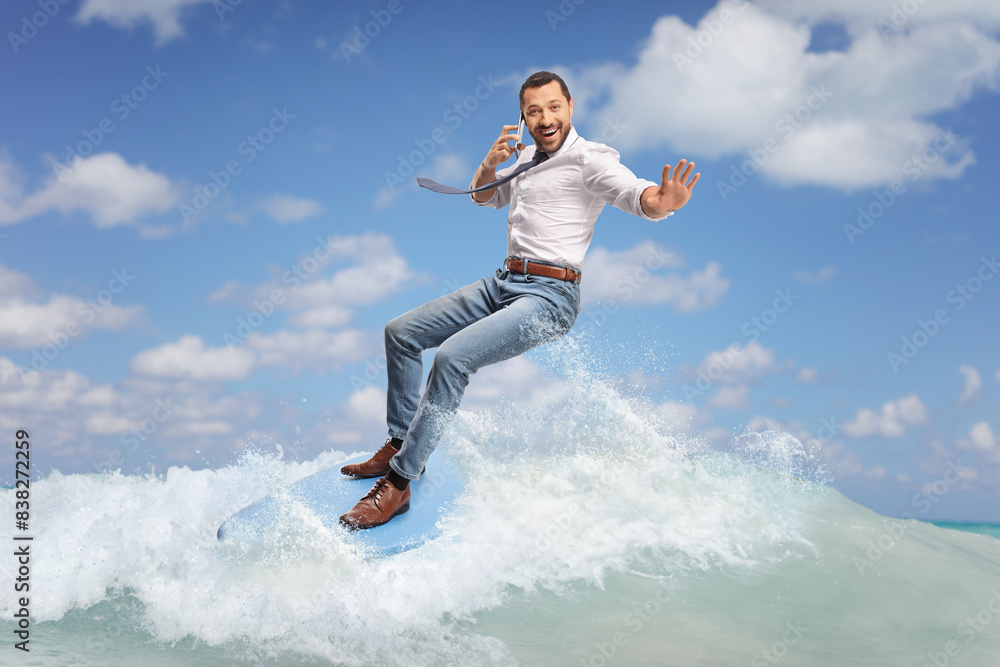 Businessman surfing on a surfboard on a wave in the sea Businessman surfing on a surfboard on a wave in the sea