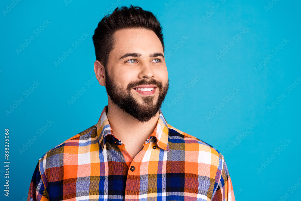 Photo of nice young man look empty space wear shirt isolated on blue color background Photo of nice young man look empty space wear shirt isolated on blue color background