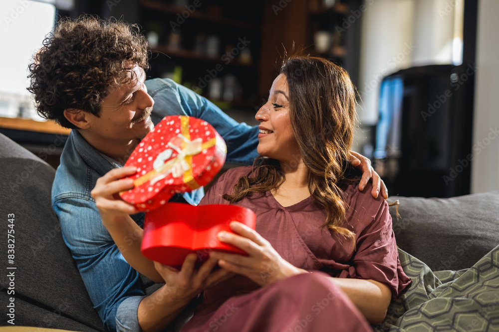 Latino husband buying his wife a present for Valentines day. She is surprised and happy. Latino husband buying his wife a present for Valentines day. She is surprised and happy.