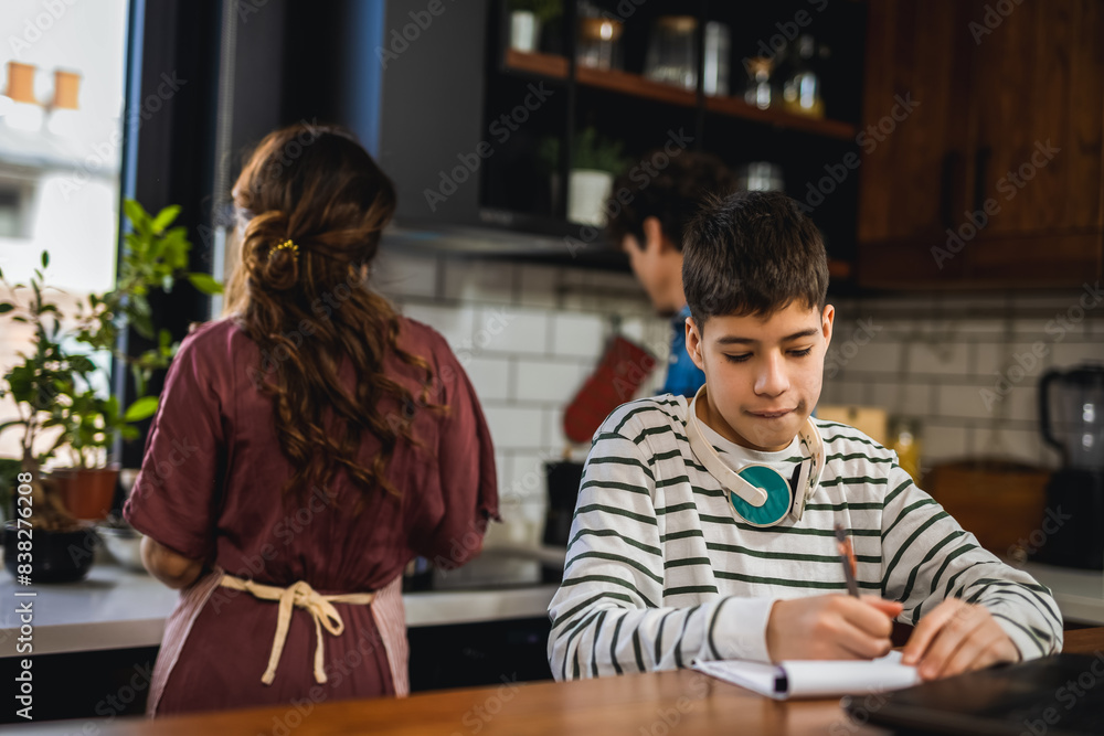 Latino boy doing his homework with the help of computer. Latino boy doing his homework with the help of computer.