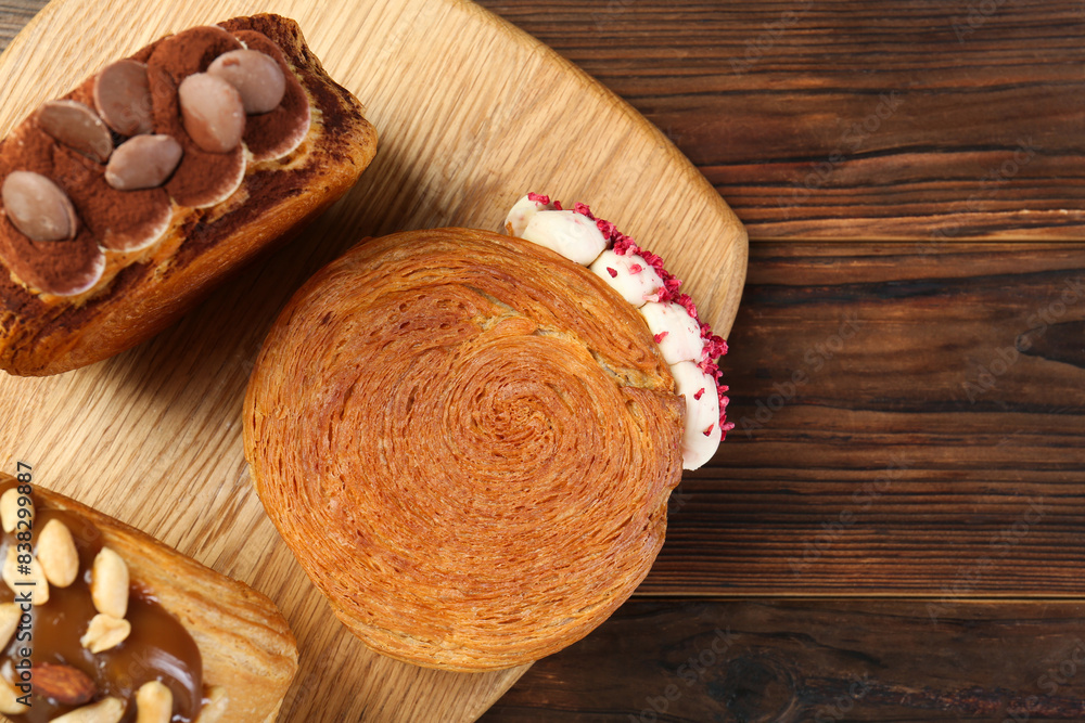 Tasty puff pastry. Round croissants on wooden table, top view. Space for text Tasty puff pastry. Round croissants on wooden table, top view. Space for text