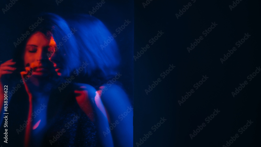 Mental pain. Defocused silhouette. Silent woman hearing voices neon red blue hands listening inner headache double exposure empty space out of focus.
