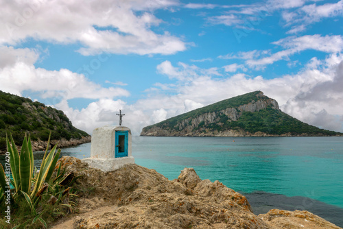 Religious Christian cross on a rock by the mediterranean sea, coastal landscape, Capo Figari near Olbia, Sardinia, Italy