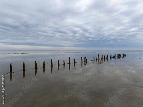 Aerial View: Wadden Sea near Wierum, Friesland, Netherlands with Wooden Posts and Stunning Cloud Reflections photo