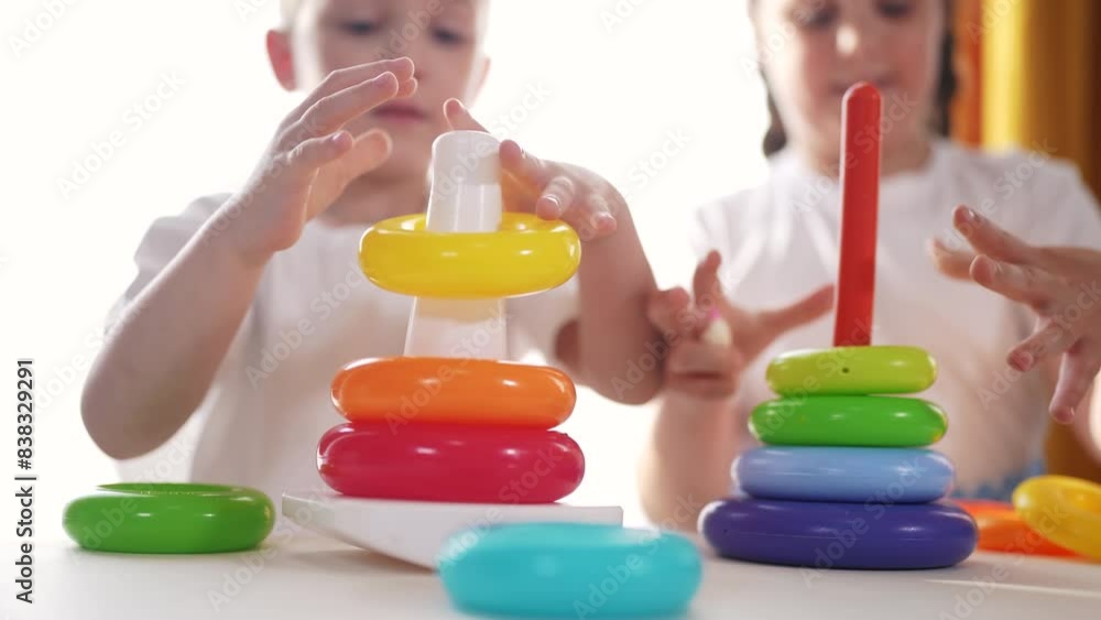 group of children a playing pyramid toy lifestyle. kindergarten development of fine motor skills concept. baby toddler brother sister collect play pyramid toy. baby children play toy group of children a playing pyramid toy lifestyle. kindergarten development of fine motor skills concept. baby toddler brother sister collect play pyramid toy. baby children play toy