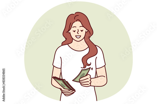 Successful woman counts money earned in business or received from dividend investments with good profit. Smiling girl with cash saves money wanting to make pension contribution or pay taxes
