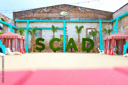 Beach with brick wall and letters that say SCAD