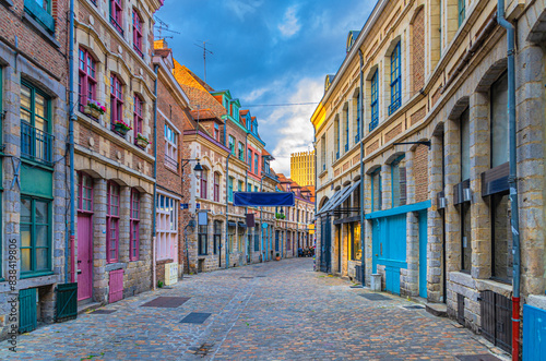 Empty narrow cobblestone street, paving stone road, old colorful buildings with brick walls in Lille historical city centre, French Flanders, Nord department, Hauts-de-France Region, Northern France