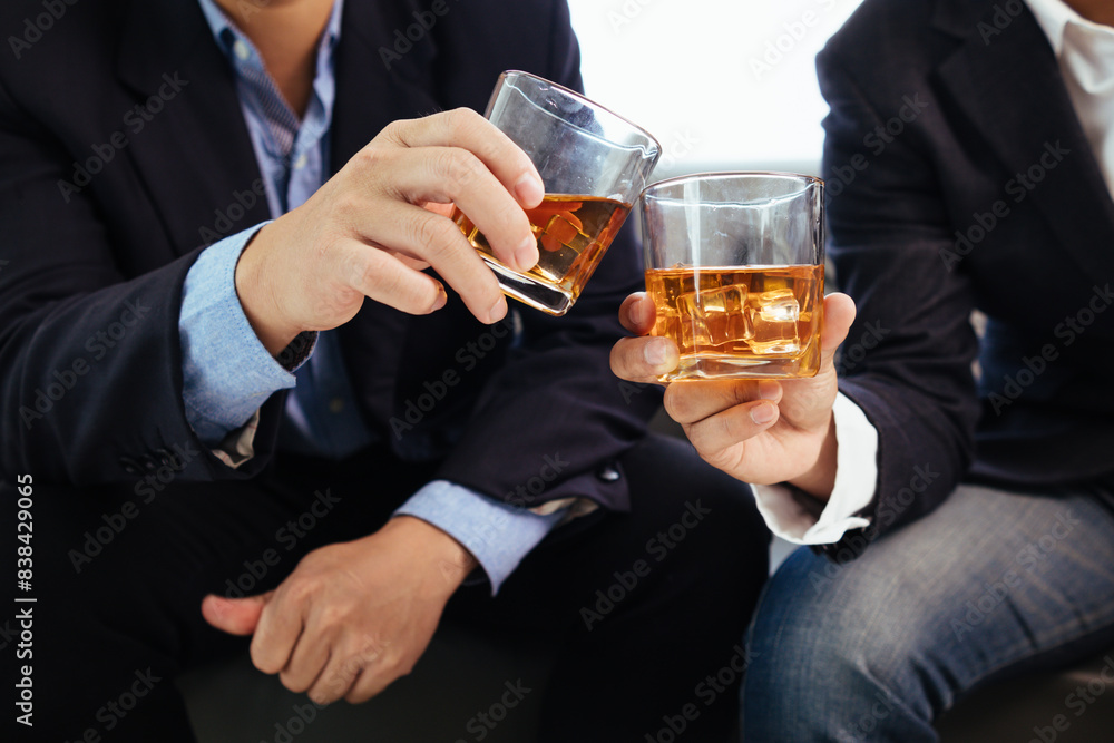 A group of businessmen held brandy glasses together to cheers glasses of brandy after concluding negotiations on business ventures and reaching a satisfactory agreement for joint business profits. A group of businessmen held brandy glasses together to cheers glasses of brandy after concluding negotiations on business ventures and reaching a satisfactory agreement for joint business profits.