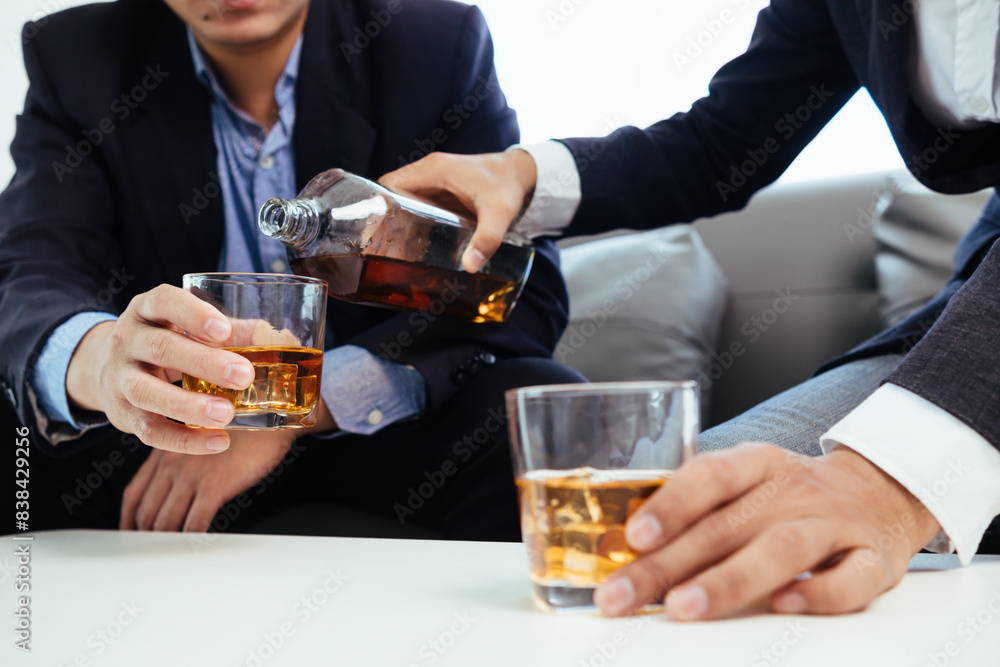 Businessmen and investors drink alcohol together in office after discussing their joint venture plans to conclusion. backdrop of alcoholic celebrations between investors and successful businessmen. Businessmen and investors drink alcohol together in office after discussing their joint venture plans to conclusion. backdrop of alcoholic celebrations between investors and successful businessmen.