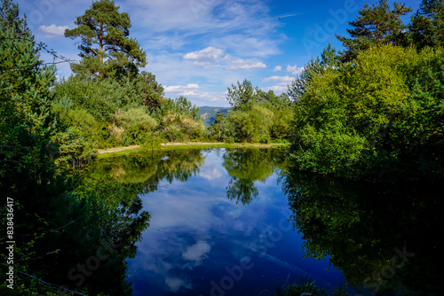 Lagoon with trees and blue sky with fluffy clouds